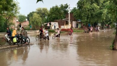 मारूफपुर बाजार में मुख्य सड़क पर पानी मे आते जाते लोग