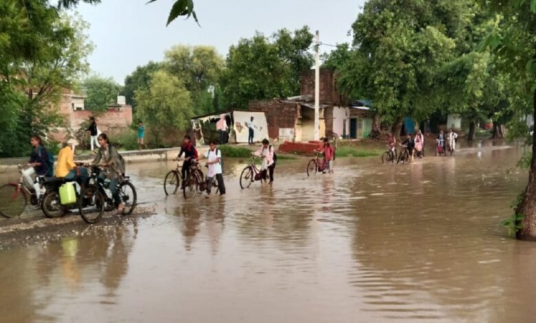 मारूफपुर बाजार में मुख्य सड़क पर पानी मे आते जाते लोग