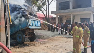 ट्रैक्टर पर लदे पुआल में लगी आग को बुझाते फायर कर्मी