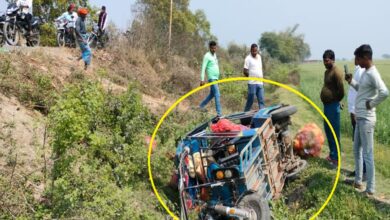 ट्रक की टक्कर से गड्ढे में पलटी ई-रिक्शा, बिखरी सब्जियाँ, मौके पर इकट्ठी भीड़।