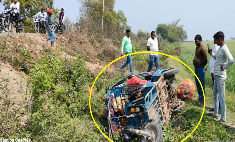 ट्रक की टक्कर से गड्ढे में पलटी ई-रिक्शा, बिखरी सब्जियाँ, मौके पर इकट्ठी भीड़।