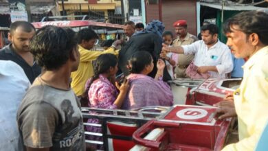 सड़क पर पलटी ई रिक्शा में फंसे लोगो को बाहर निकलते लोग