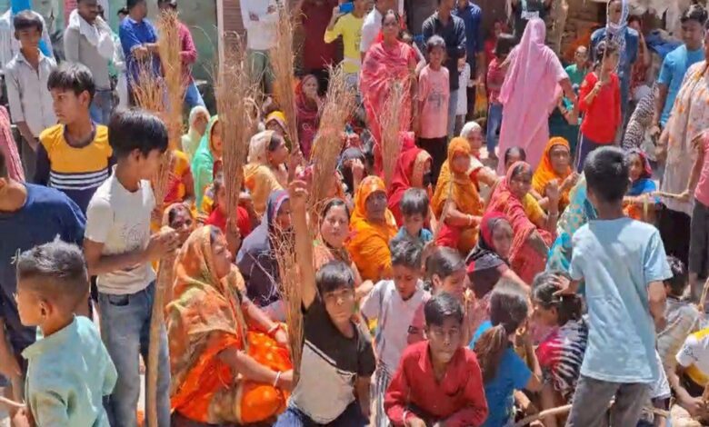 हाथ में झाड़ू लेकर धरना प्रदर्शन करती महिलाएं