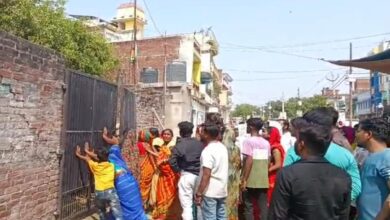 बाउंड्री का दरवाजा बंद कर विरोध करते स्थानीय लोग