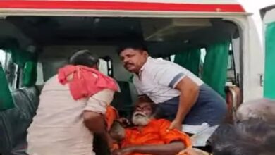 मोहनपुरवा में वृद्ध को उठाकर एम्बुलेंस में रखते सपा नेता भोला नाथ यादव