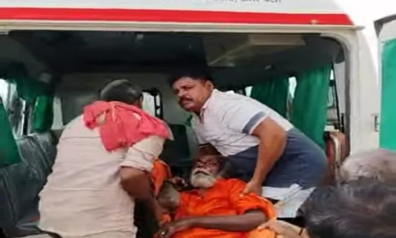 मोहनपुरवा में वृद्ध को उठाकर एम्बुलेंस में रखते सपा नेता भोला नाथ यादव