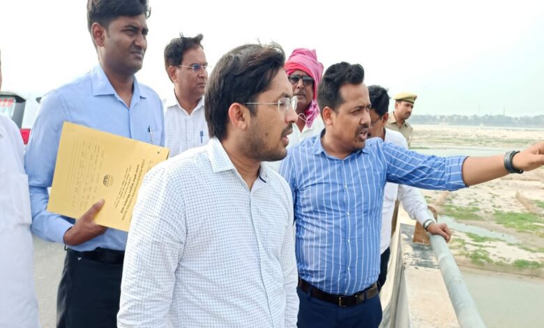 तीरगांव में पुल से गंगा कटान की स्थिति का जायजा लेते जिलाधिकारी
