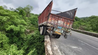 डिवाइडर पर लटका ट्रक