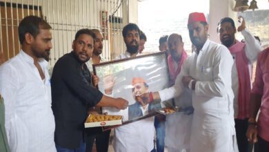 अखिलेश यादव की तस्वीर को मिठाई खिलाते सपा नेता संतोष यादव